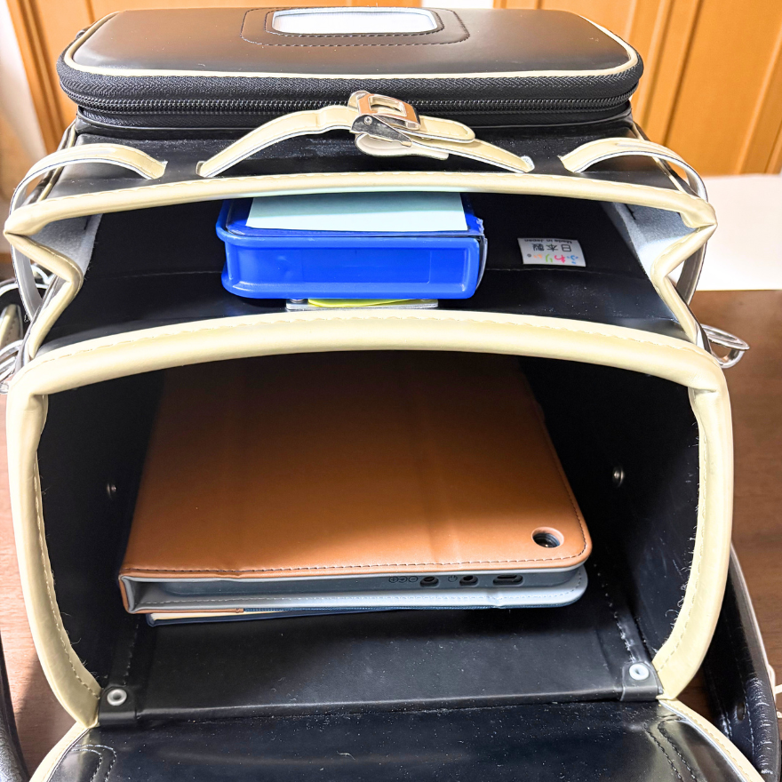 小学5年生のふわりぃ「スーパーフラッシュ」のランドセルを開いて、タブレットが入った中身を見せている写真